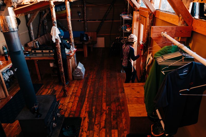 Big Belt Hut Interior: Stove, Kitchen, & Dining area.
