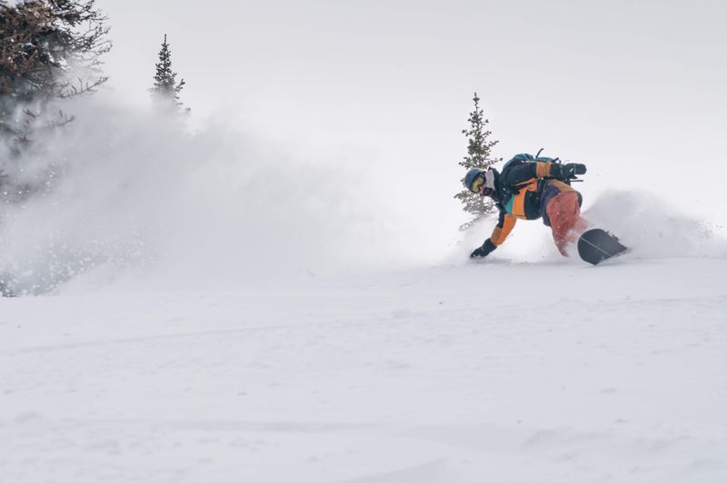 Snowboarder slashing powder outside Big Belt Hut